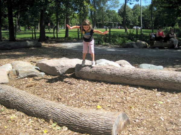 Girl balancing on large log at Discovery Hollow, Tamarack Nature Center