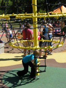 Child climbing web at Elm Creek Play Area