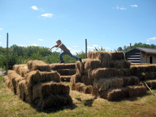 child playing on hay bales at Cider Flats Orchard