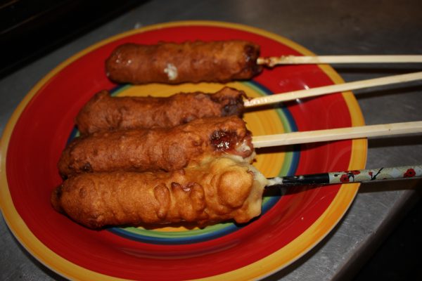 Four homemade corndogs on a plate