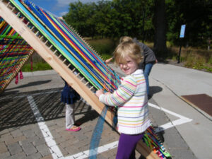 Kids weaving on a giant loom at Silverwood Fieldtrip at Silverwood Park in St. Anthony, Minnesota