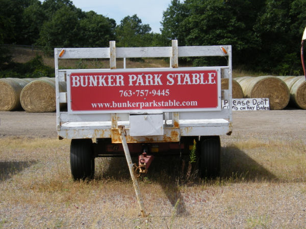 Trailer with sign "Bunker Park Stable - 763-757-9445 - www.bunkerparkstable.com