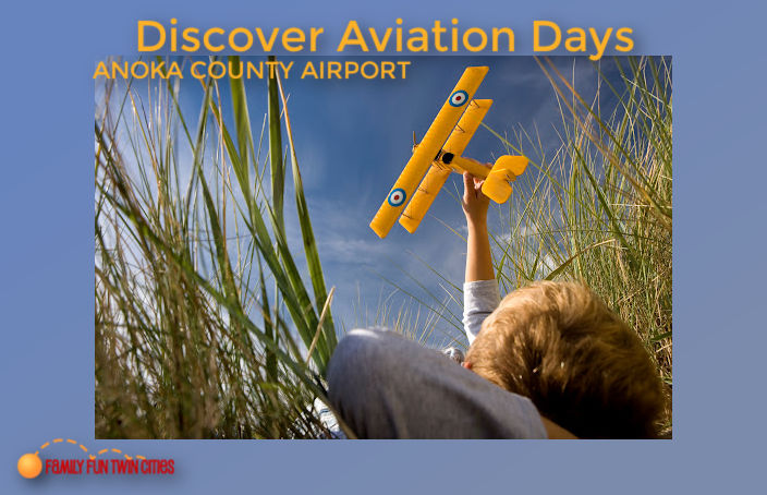 Boy laying in the grass and playing with a yellow airplane as he looks at the sky