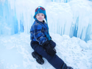 Young man sitting in an Ice Castle Throne in Minnesota