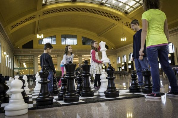 Group of children playing a life-size chess game during Games Galore at Union Depot Station in St. Paul, MN,