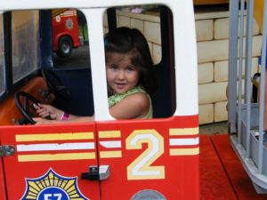 Girl driving a Fire Truck when Family Fun Twin Cities visited Como Town Amusement Park in Saint Paul, Minnesota