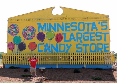 Boy standing in front of Minnesota's Largest Candy Store sign