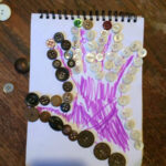 Child's hand traced and outlined with buttons.