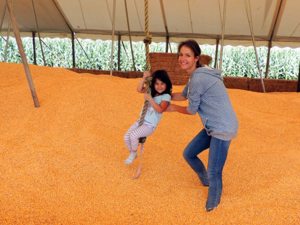 Mother and daughter playing on swing in corn pit at Sever's Corn Maze in Shakopee, Minnesota