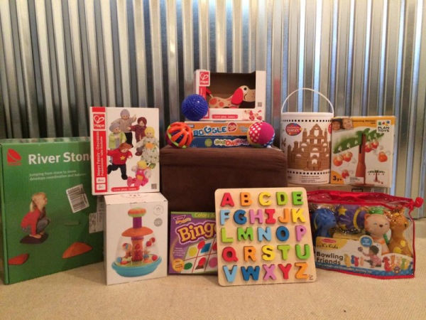 An example of preschool-age toys offered at the Minneapolis Toy Library, including River Stones Stepping Game, alphabet buzzle, bingo, pull behind toys, blocks, Bowling Friends game and dolls.