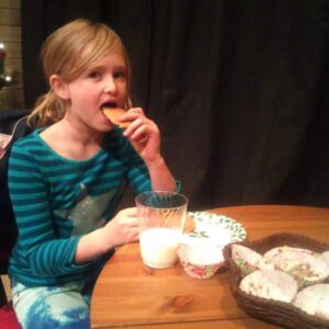 Girl eating Christmas cookies and drinking milk