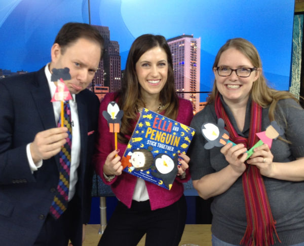WCCO's Jason DeRusha, Author Megan Maynor (with her book Ella and Penguin Stick Together) and Gianna Kordatzky of Family Fun Twin Cities show their Ella and Penguin puppets