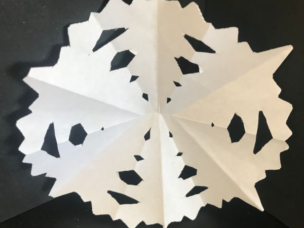 White paper snowflake on a black background