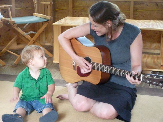 Sarah McCaffrey Ritchie, owner of Songs with Sarah, playing guitar for small boy