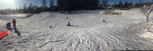 Kids sledding on slope between Edison High School and Jackson Park in NE Minneapolis, MN