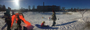Families sledding on slope between Edison High School and Jackson Park in NE Minneapolis, MN