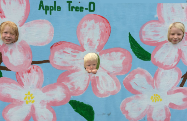 Kids faces in Flower Cut Outs for Family Fun at Apple Tree-O in Delano, Minnesota