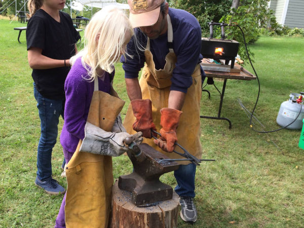 Girl learning to blacksmith at Apple Tree-O Orchard in Delano, Minnesota