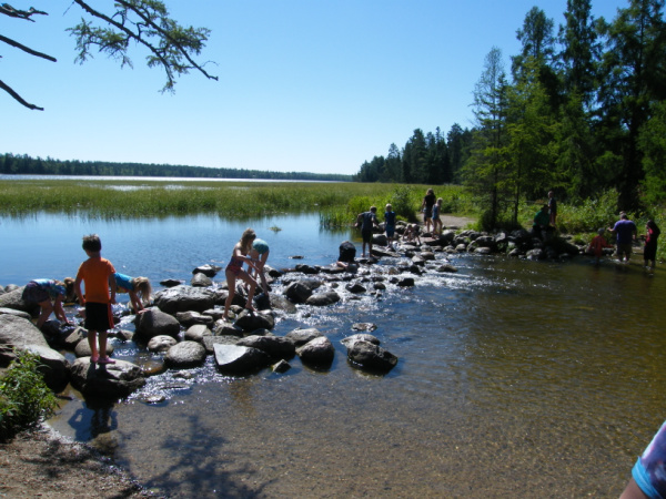 Families exploring rock-bridge at the headwaters of the Mississippi River in Itasca State Park, Park Rapids, Minnesota