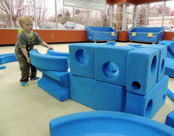 Small boy building with blue foam blocks on the Imagination Playground at Good Times Park in Eagan, Minnesota