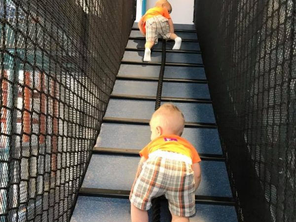 Toddler boys climbing the Scramble at the Minnesota Children's Museum in Saint Paul, MN.
