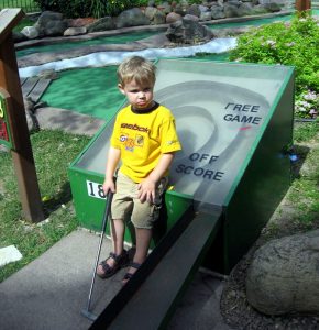 Boy playing a game of mini golf at Como Zoo in Saint Paul, Minnesota