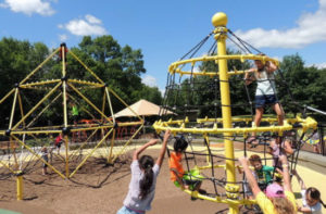 Kids spinning and swinging on playground at Elm Creek Park in Maple Grove, Minnesota