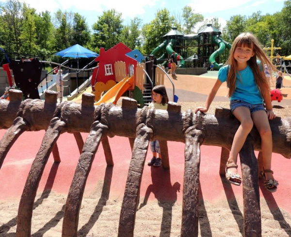 Girl climbing "Dinosaur" bones at Elm Creek Playground in Maple Grove, Minnesota