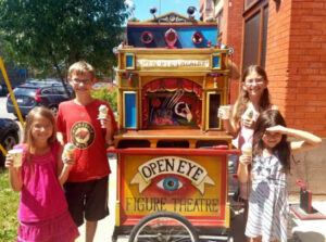 Kid-Friendly Theater - Kids standing by Open Eye Theare's Puppet Wagon