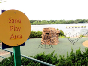 Sand Play Area sign in front of climbing structures at Shady Oak Beach in Minnetonka Minnesota