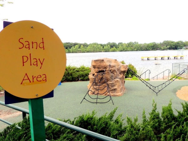 Sand Play Area sign in front of climbing structures at Shady Oak Beach in Minnetonka Minnesota