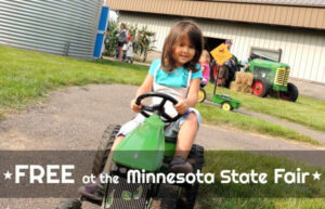 Girl driving a mini tractor at the Lil Farmhands attraction at the Minnesota State Fair