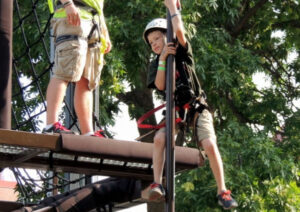 Boy sliding down pole of boy scout summit at the Minnesota State Fair