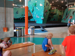 Children trying on climbing shoes at the Minneapolis Bouldering Project to find the perfect fit before wall climbing