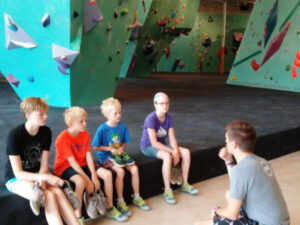 An instructor at Minneapolis Bouldering Project explains rules and procedures to a group of children prior to climbing.