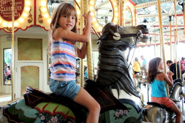 Girl riding a horse on Cafesjian's Carousel at Como Park in Saint Paul, Minnesota