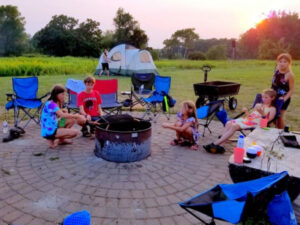 Family roasting marshmallows around a campfire at Lake Elmo Park Reserve in Lake Elmo, Minnesota.