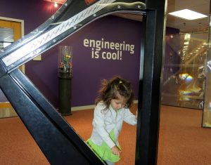 Toddler playing a large harp at The Works Museum in Bloomington Minnesota