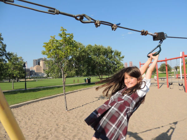 Girl ziplining on playground of Harriet Island Park in Saint Paul Minnesota
