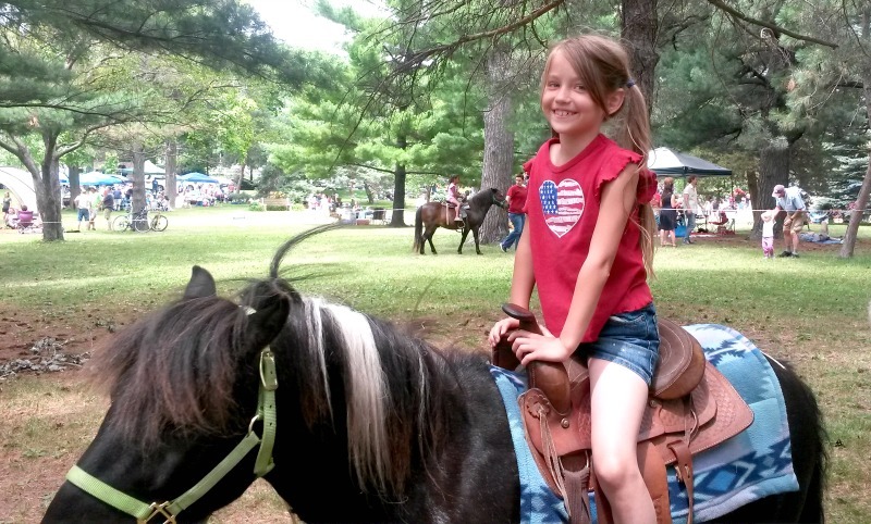Girl Riding Pony during Independence Day celebration at Langford Park, Saint Paul Minnesota 