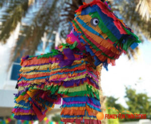 Large colorful piñata of a dog in rainbow colors.