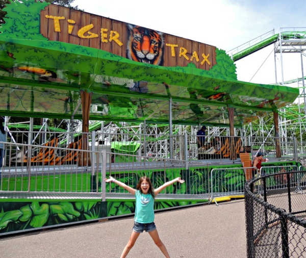 Excited girl in front of the Tiger Trax roller coaster at Como Town Amusement Park in Saint Paul Minnesota