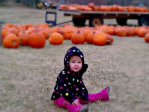 Baby by pumpkin patch at Pleasant Valley Orchard in Shafer, Minnesota