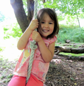 Girl swinging on Rope at Maple Hollow in Wargo Nature Center in Minnesota