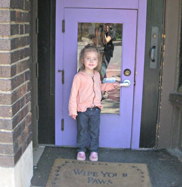Girl standing in front of the tiny people door at the Wild Rumpus Bookshop in Minneapolis, Minnesota