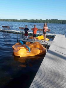 three kids float in a paddleboat