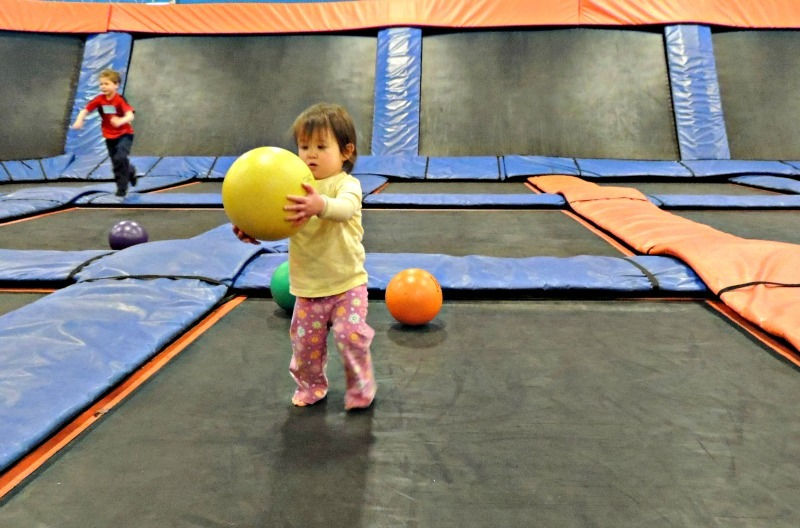 Toddler playing with bouncy ball at Sky Zone Trampoline Park