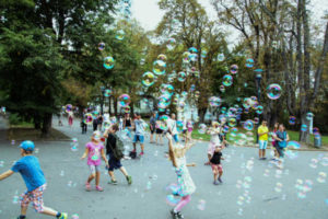 Children chasing bubbles in the street