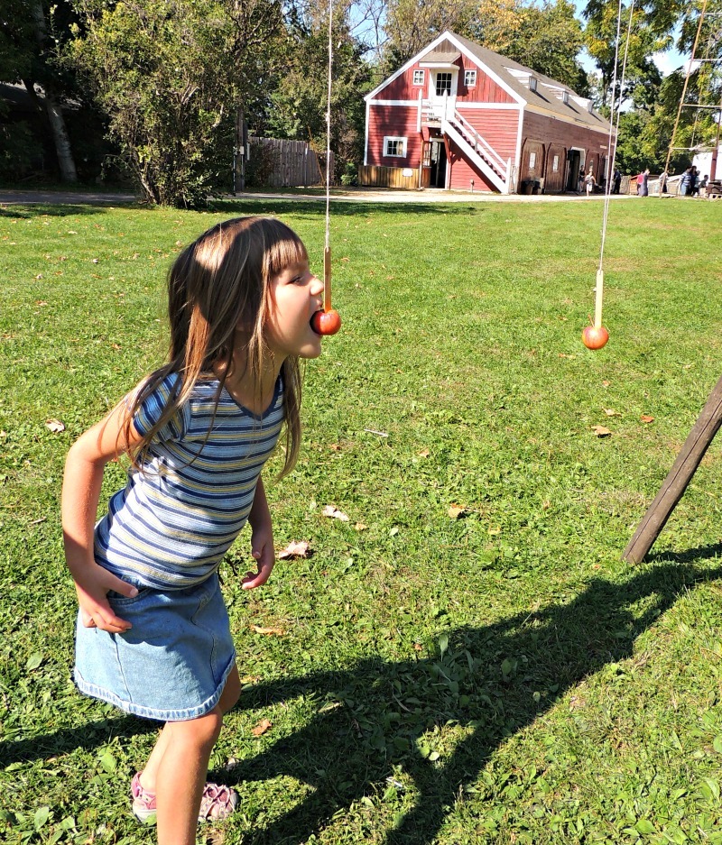 Girl playing apple game at Gibbs Museum of Pioneer and Dakotah Life