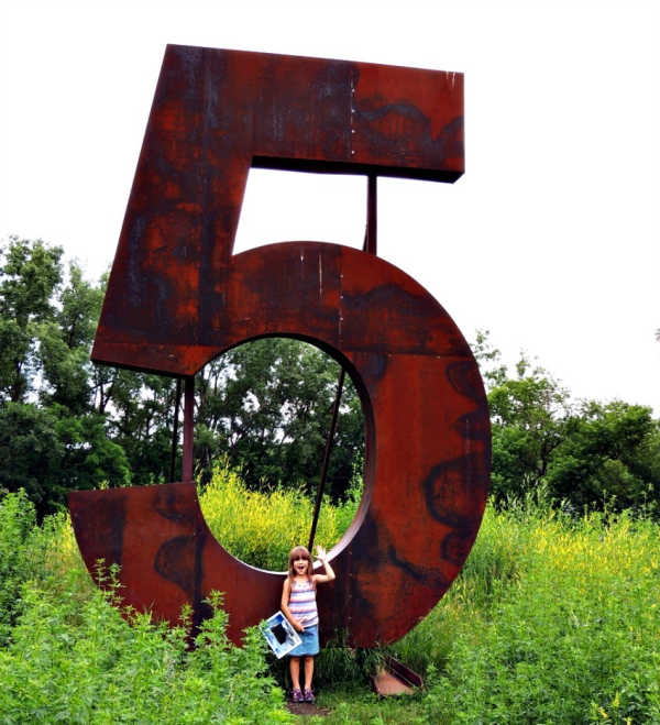 Girl standing in front of the #5 at Silverwood Park in Saint Anthony, Minnesota